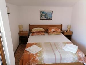 a bedroom with a bed with two pillows at Guesthouse Olimp in Sozopol