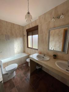 bagno con 2 lavandini, servizi igienici e vasca di Casa Rural Matillas a Bienservida