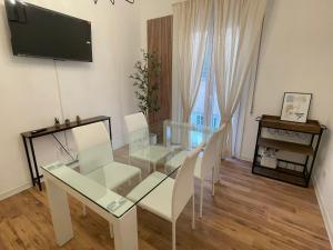 a dining room with a glass table and white chairs at 'La Perla' nel centro di Frascati in Frascati