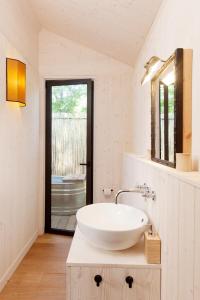 a white bathroom with a sink and a tub at Glamping Terre di Sacra in Tuscany in Capalbio