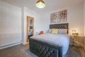 a bedroom with a large bed and a mirror at Modern Home: Heart Of Blackburn in Blackburn