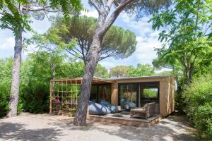 una pequeña casa en el bosque con un árbol en Glamping Terre di Sacra in Tuscany en Capalbio