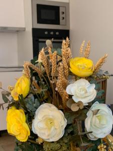 un bouquet de fleurs jaunes et blanches dans un vase dans l'établissement La parisienne, à Le Raincy