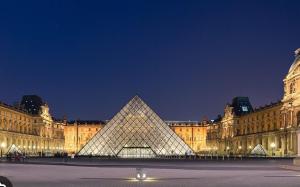 een uitzicht op de louvre piramide voor een gebouw bij La parisienne in Le Raincy