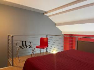 a bedroom with a red bed and a chair at Easy Space in Bientina