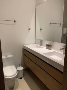 a bathroom with a toilet and a sink and a mirror at Oasis Retreat - Cartagena in Los Arrayanes