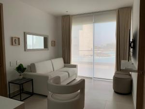 a living room with a white couch and a window at Oasis Retreat - Cartagena in Los Arrayanes
