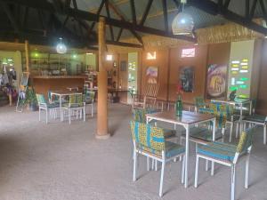a dining room with tables and chairs and a table at Gaia Eco Hub BnB in Fort Portal