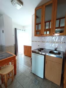 a kitchen with a stove and a sink and a table at Vila Pašić in Igalo