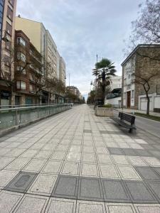 an empty street with a bench in a city at La casa de las Flores in Ponferrada