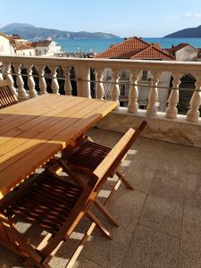 - une table en bois sur un balcon avec vue sur l'océan dans l'établissement Vila Pašić, à Igalo