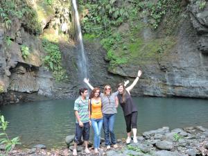 a group of people standing in front of a waterfall at Eco-Cabañas Altozano Nimaima in Nimaima