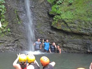 un grupo de personas en el agua cerca de una cascada en Eco-Cabañas Altozano Nimaima, en Nimaima