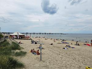 a group of people on a beach with a pier at Ferienwohnung Ostseekult in Międzyzdroje