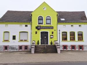 a yellow and white building with stairs in front at Hotel Kulturhaus Felgeleben in Schönebeck