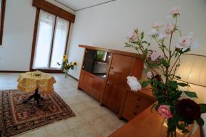 salon ze stołem i wazą kwiatów w obiekcie Appartamento Colli & Terme w mieście Battaglia Terme