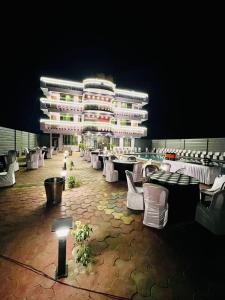 ein Gebäude mit weißen Stühlen und Tischen sowie einem Gebäude in der Unterkunft Roshan Resorts in Bhopal