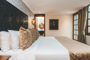 a bedroom with a large white bed with pillows at Hotel Cruz del Vado by Art Hotels in Cuenca