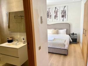 Un dormitorio con una cama, un lavabo y un espejo. en New appart, pool and golf view, en Marrakech 21 fotos más