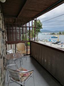 balcón con mesa, sillas y vistas al agua en Guesthouse Olimp, en Sozopol