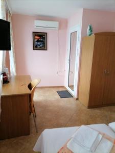 a bedroom with a desk and a room with a bed and a deskictericter at Guesthouse Olimp in Sozopol