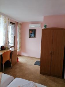 a room with a desk and a cabinet and a bedroom at Guesthouse Olimp in Sozopol