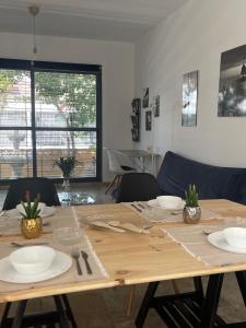 - une table en bois avec des assiettes et des ustensiles dans l'établissement Glass Student-Übica2 Guesthouse, à Mairena del Aljarafe
