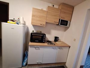 a small kitchen with a microwave and a refrigerator at Hotel Kulturhaus Felgeleben in Schönebeck