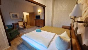 ein Hotelzimmer mit einem Bett und einem Stuhl in der Unterkunft Hotel Kulturhaus Felgeleben in Schönebeck
