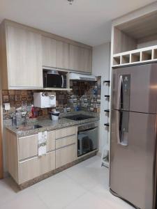 a kitchen with a stainless steel refrigerator at Brisas do Lago Diária Brasil 67961 in Brasilia