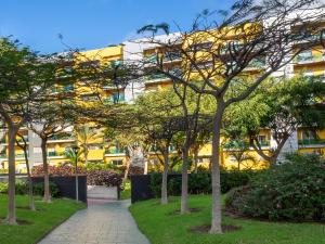 una fila de árboles frente a un edificio en Apartment Abora Garden with terrace, pool, extensive gardens and free parking, en Las Palmas de Gran Canaria