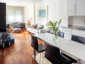 a kitchen and living room with a table and chairs at Apartment Abora Garden with terrace, pool, extensive gardens and free parking in Las Palmas de Gran Canaria