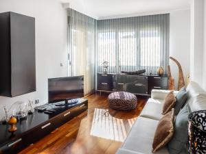 a living room with a couch and a flat screen tv at Apartment Abora Garden with terrace, pool, extensive gardens and free parking in Las Palmas de Gran Canaria