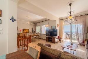 a living room with a couch and a dining room at Casa Del Mar in Neos Marmaras
