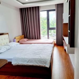 two beds in a room with a window at Homestay Thule in Ho Chi Minh City
