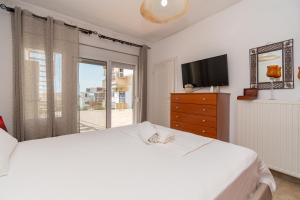 um quarto branco com uma cama grande e uma televisão em Casa Del Mar em Neos Marmaras