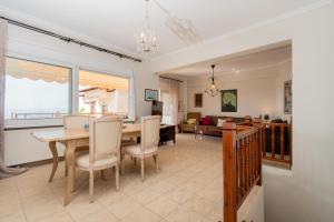 uma sala de jantar e sala de estar com mesa e cadeiras em Casa Del Mar em Neos Marmaras