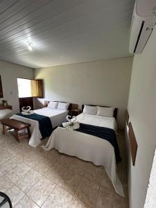 Apt quarto 228 - hotel pedra Rodeadouro-Bonito-PE في بونيتو: سريرين في غرفة فندق مع