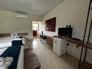 Apt quarto 228 - hotel pedra Rodeadouro-Bonito-PE في بونيتو: غرفة بسرير وتلفزيون في غرفة