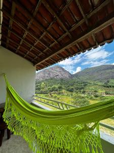a hammock in a room with mountains in the background at FLAT 228 - Hotel Pedra do Rodeadouro-Bonito-PE in Bonito