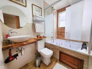 a bathroom with a sink and a toilet and a tub at Pousada Geada de Campos in Campos do Jordão
