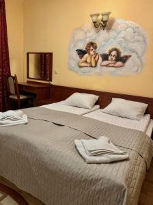 a bedroom with two beds with angels on the wall at Лаціо in Berehove