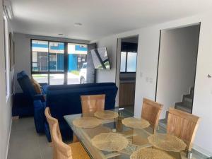 a living room with a glass table and chairs at Casa Familiar Excelente ubicación con Piscina in La Tebaida