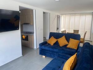 ein blaues Sofa mit gelben Kissen im Wohnzimmer in der Unterkunft Casa Familiar Excelente ubicación con Piscina in La Tebaida