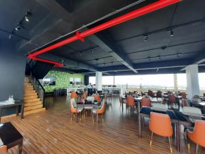 a restaurant with tables and chairs and a red beam at Ocean Breeze Aparthotel Negombo R11 B01 in Negombo