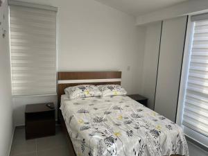 a bedroom with a bed with a comforter and pillows at Casa Familiar Excelente ubicación con Piscina in La Tebaida