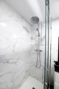y baño con ducha y paredes de mármol blanco. en Venecia1, en Pobra do Caramiñal