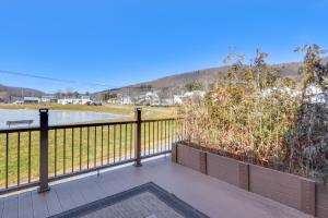 a balcony with a fence and a view of a field at Smethport Vacation Rental with Fireplace and Lake View 