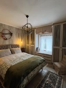 a bedroom with a large bed and a chandelier at 1957 To Rodo kai to Roido in Karpenisi