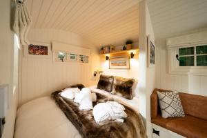 a room with a bed with white pillows at Shepherd's Rest Luxurious Hideaway in Glasgow